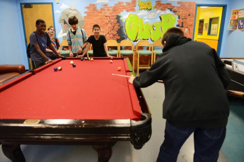 Braden Schroeder , 13, shoots pool, while (from left) Kameron Jackson, Matthew Haghirian,...