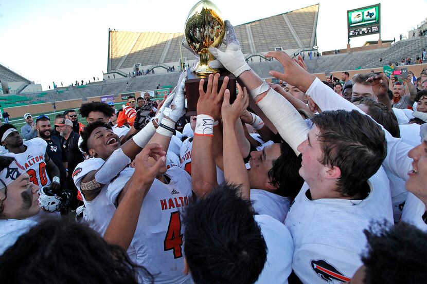 Haltom High School hoists up their trophy after they defeated Hebron High School 41-30 in a...