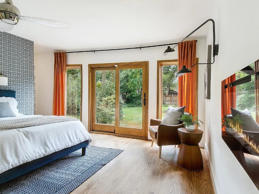 Bedroom with accent wall, orange curtains, a reading nook and a built-in fireplace