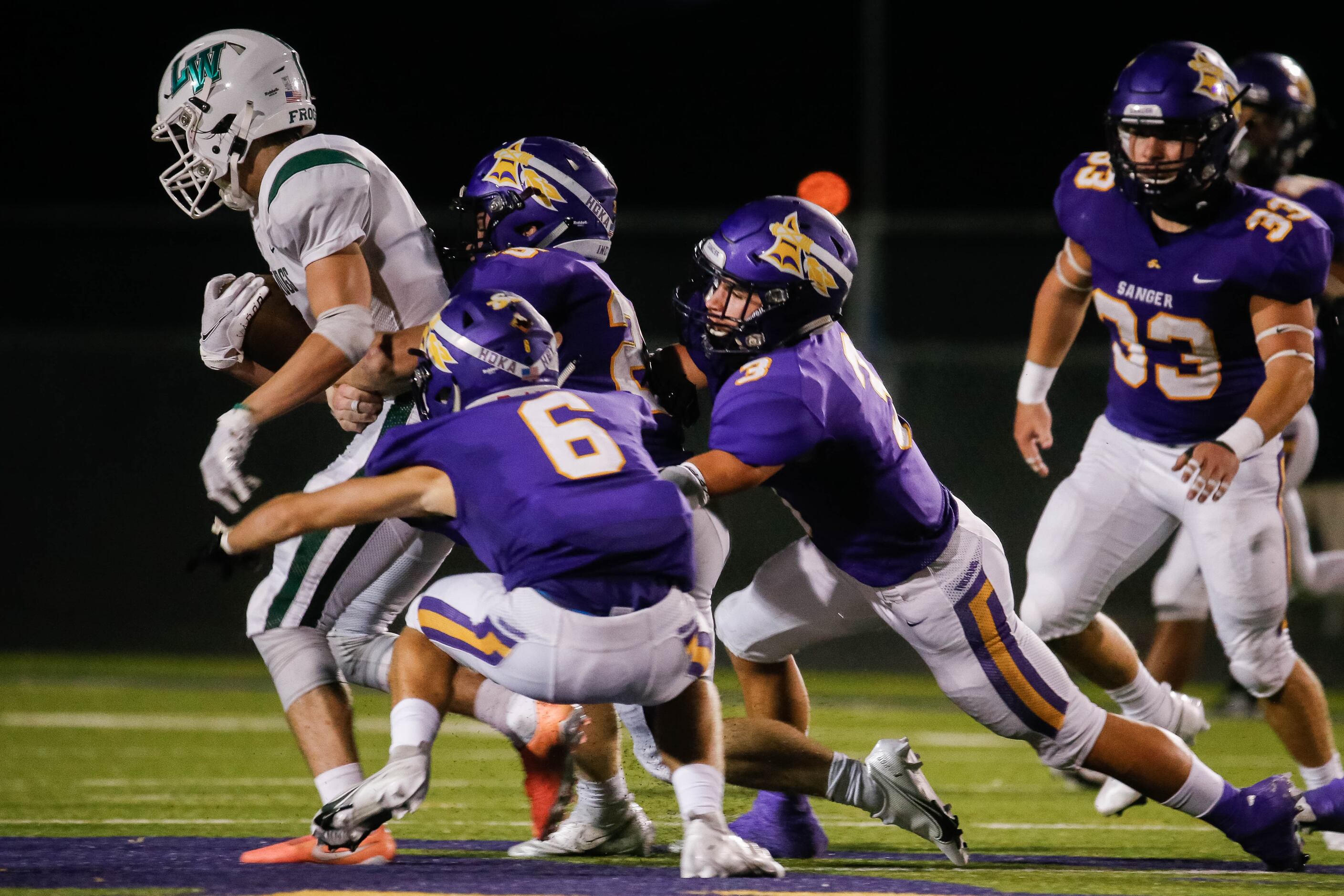 Lake Worth High School's Mark Fulkerson (5) is taken down by the Sanger High School's...