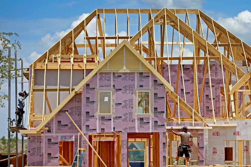 Construction workers frame new homes inside the Walsh development in Fort Worth on Thursday,...