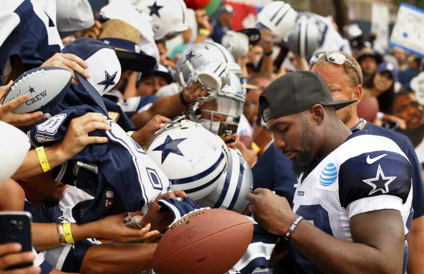 Dallas Cowboys wide receiver Dez Bryant (88) signs autographs for fans following afternoon...