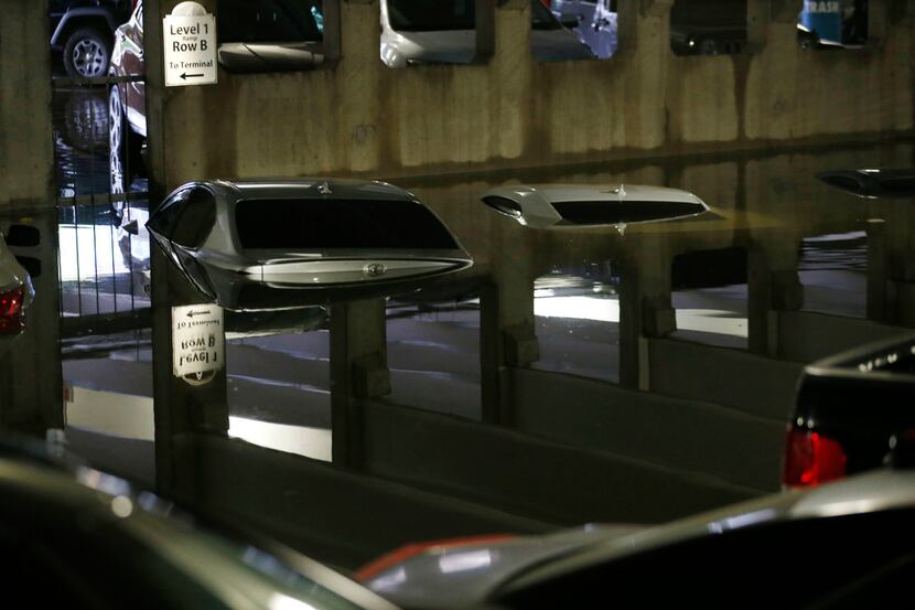 Flooded cars parked in the lower level of parking garage A at Dallas Love Field under water...