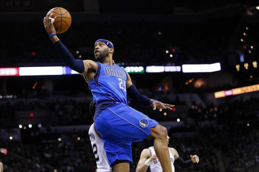 Dallas Mavericks guard Vince Carter (25) does a spin move as he goes to the basket against...
