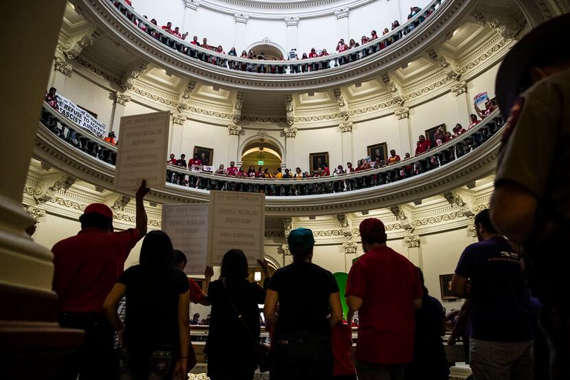 Hundreds of protesters line the balconies of the state Capitol rotunda in Austin on Monday,...
