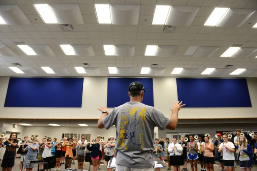 Band director Glenn Lambert conducts students during a band practice in the new band hall at...