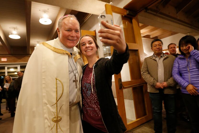 Lindsey Rohr (right) takes a selfie with Bishop Edward Burns, the new bishop of Dallas, as...