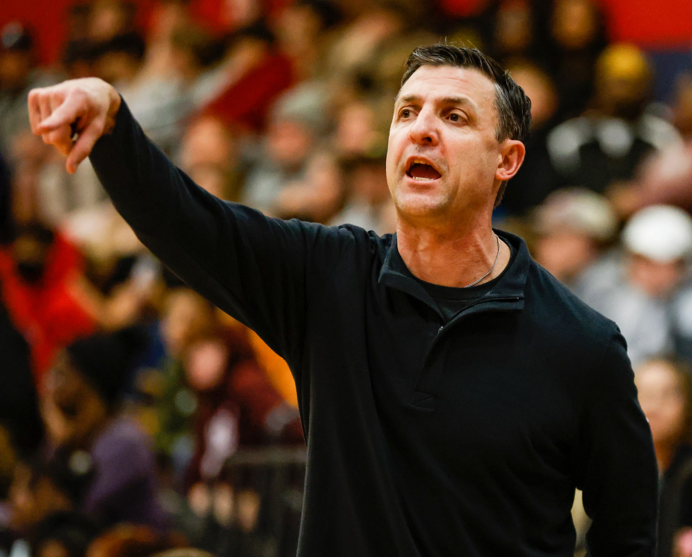 The Colony High School head coach Cleve Ryan talks to players on the court in the first...