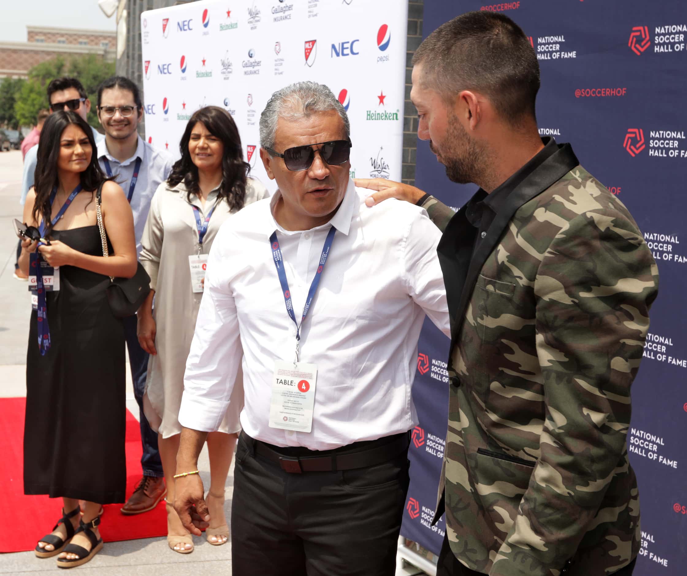 Marco Etcheverrycenter, shares a moment with Clint Dempsey, right, on the red carpet during...
