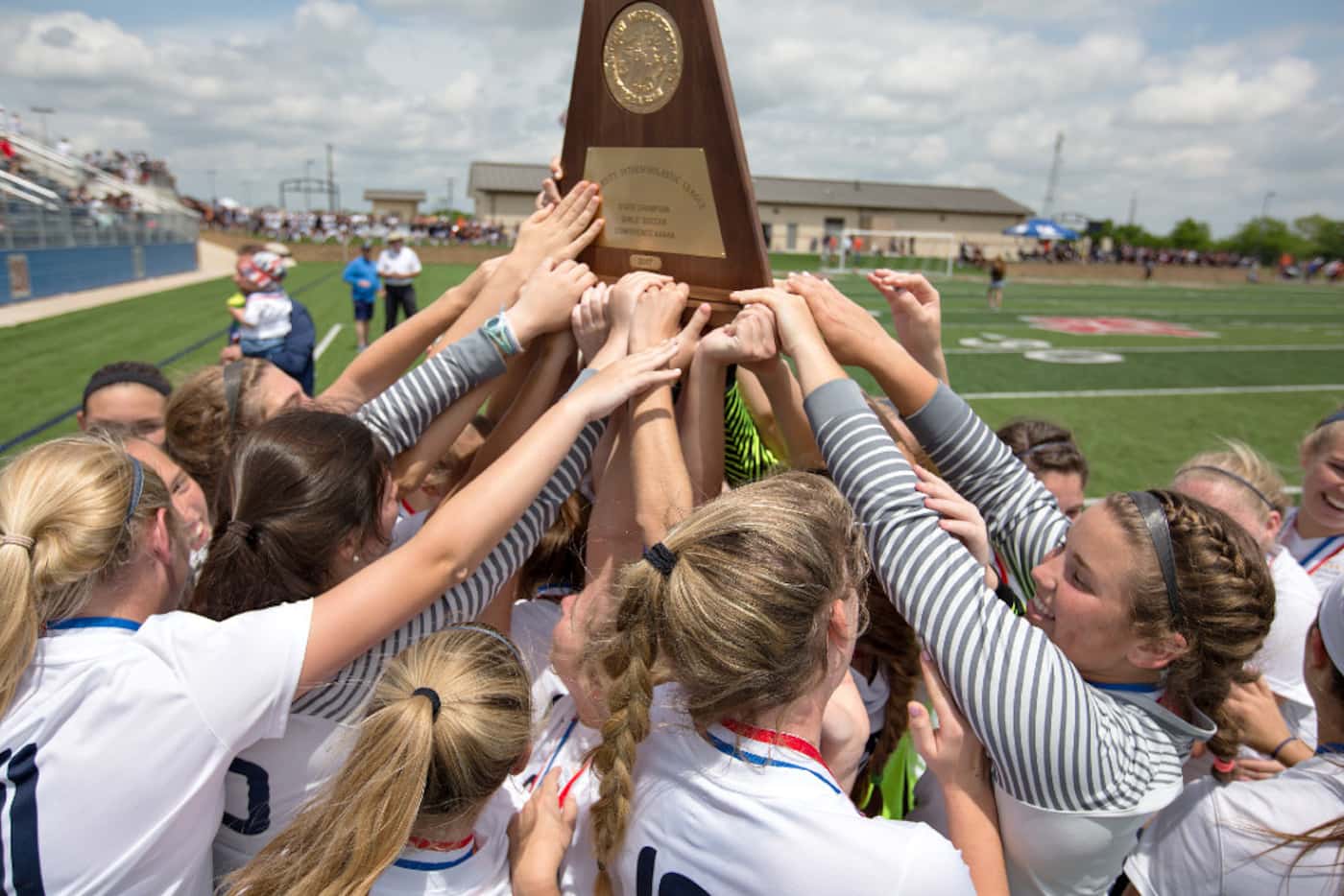 Highland Park players hoist up their state championship trophy after their win over Aledo...