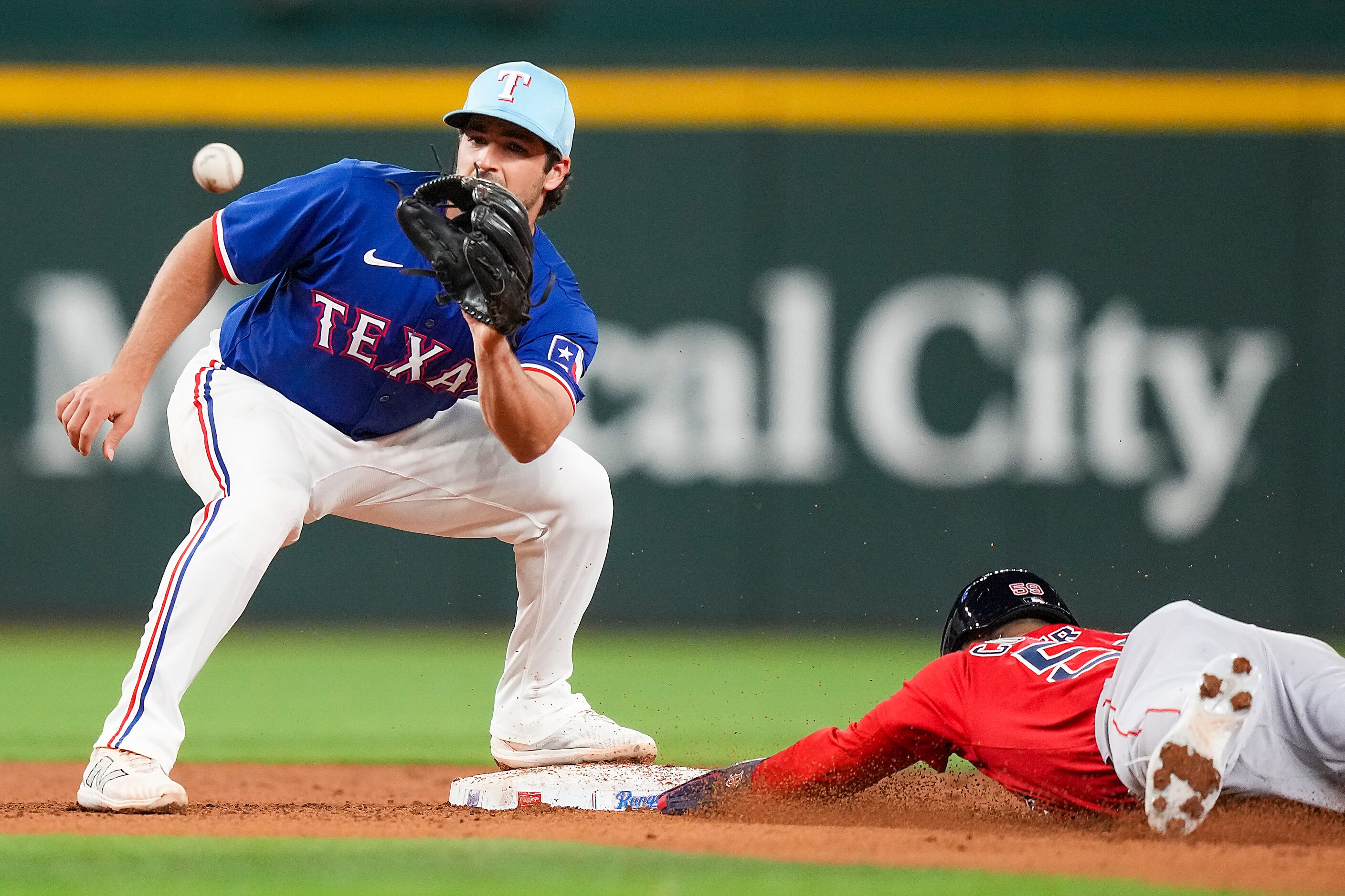 Mark Contreras of the Boston Red Sox is safe at second base ahead of the throw to Texas...