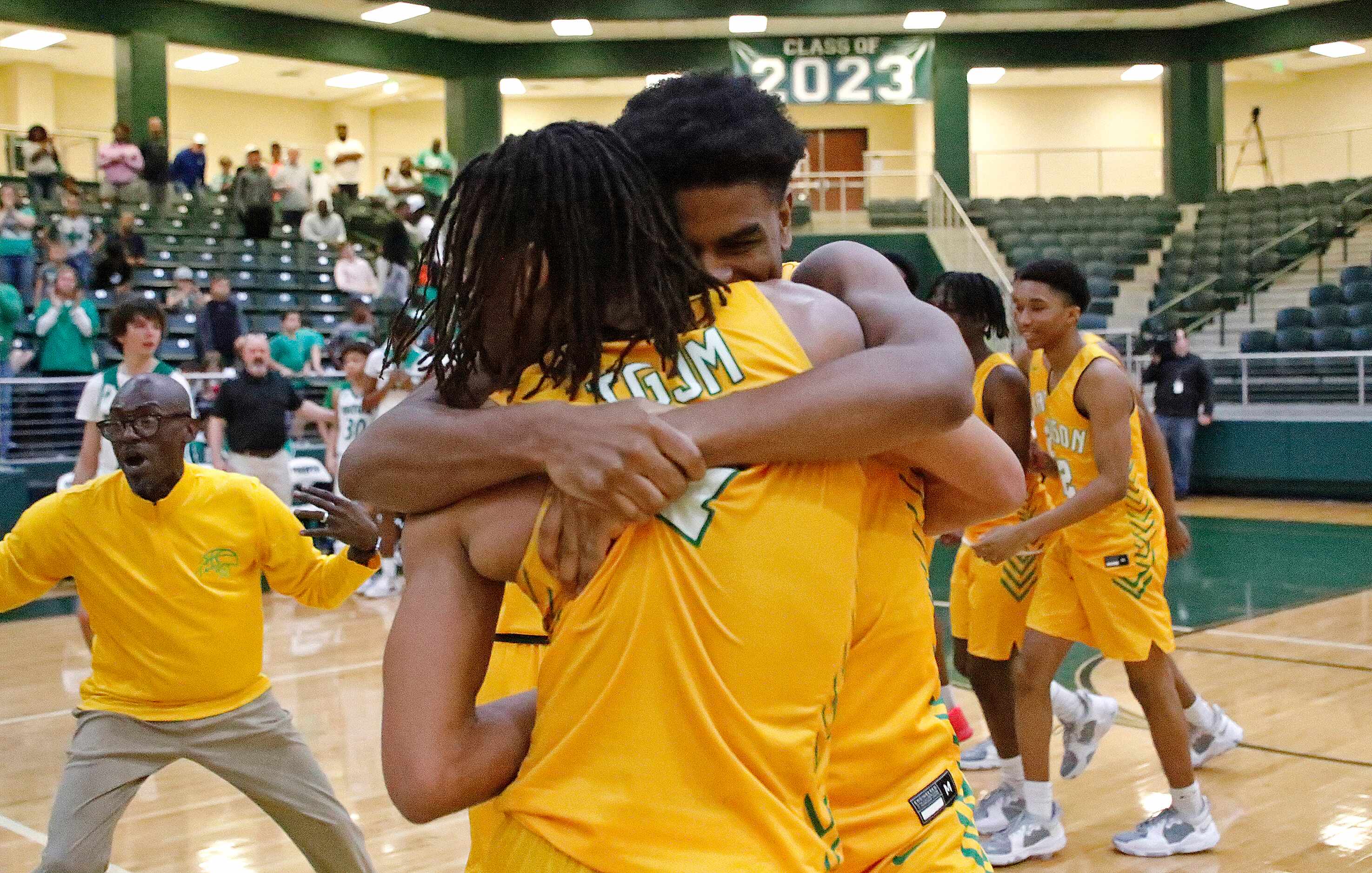 Madison gaurd Pierre Hunter (1) is embraced by Madison forward Jordan McCullough (20) after...