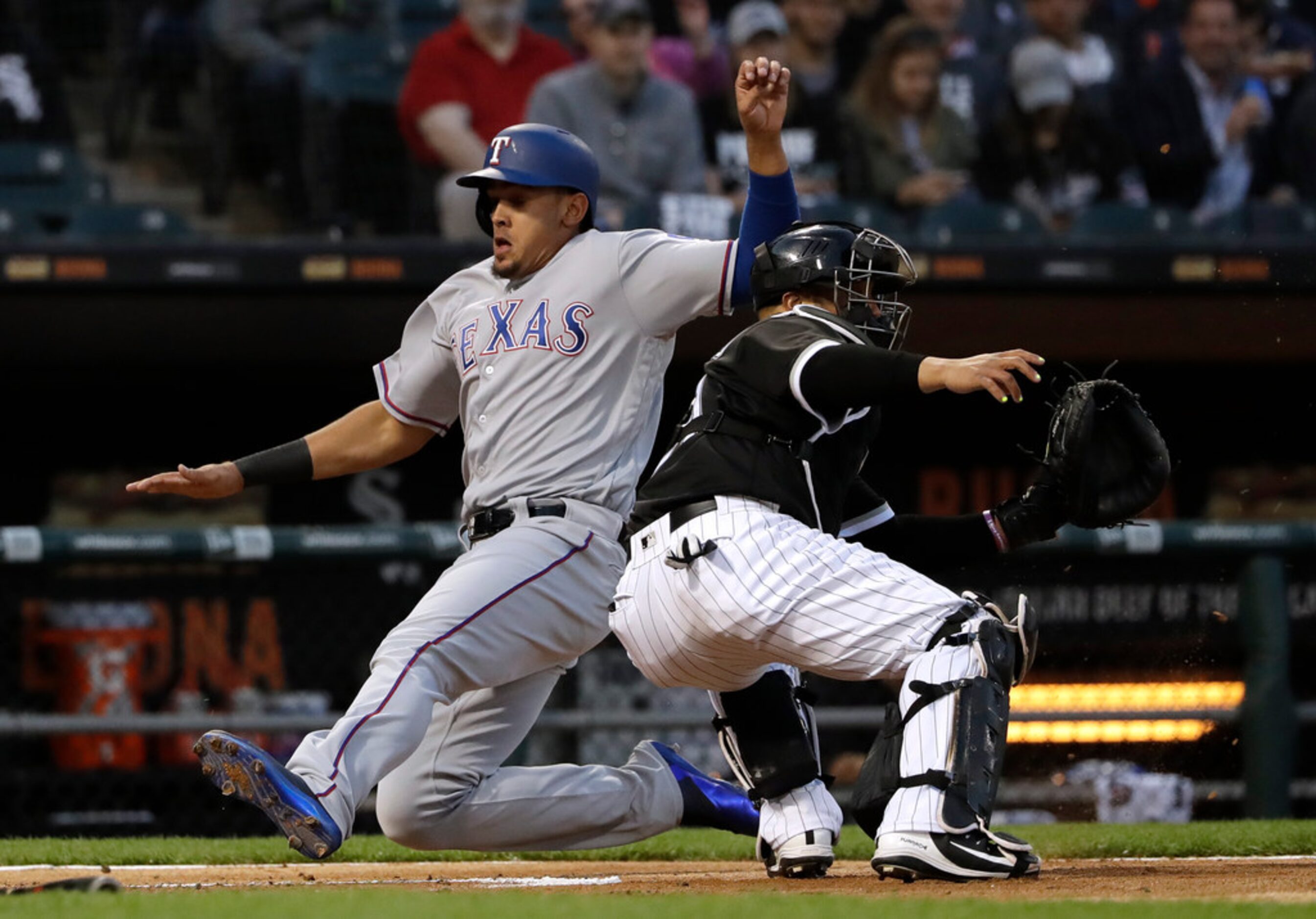 Texas Rangers' Ronald Guzman, left, scores on a single by Shin-Soo Choo as Chicago White Sox...