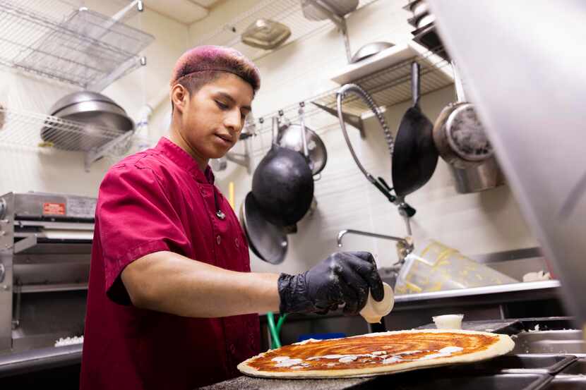 Ricky Saquic prepares a pizza order at Pizza Large on Thursday, Sept. 22, 2022, in Dallas. 