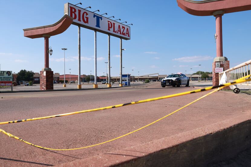 Police cars sit outside Big T Plaza in Dallas after a homicide was reported Saturday.