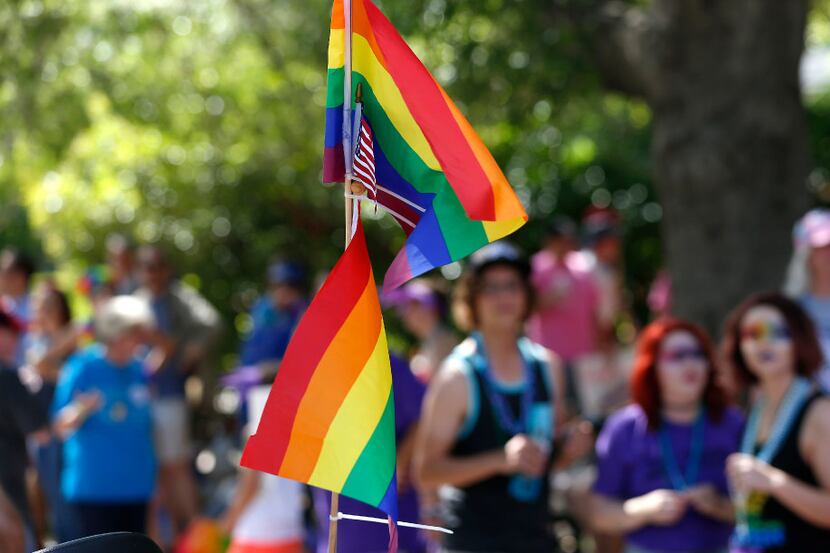 Rainbow flags and an American flag flew during a Dallas LGBT pride parade. In October, Pride...