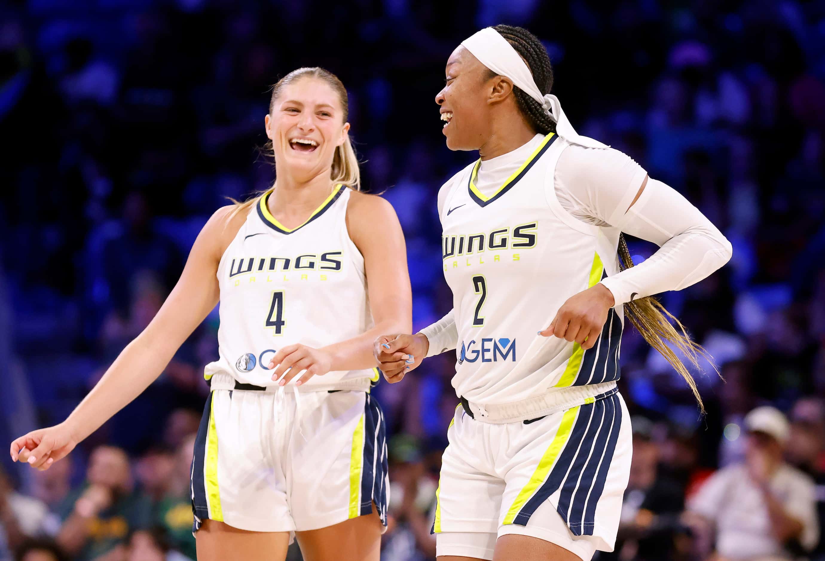 Dallas Wings guards Odyssey Sims (2) and Jacy Sheldon (4) begin to celebrate their win over...