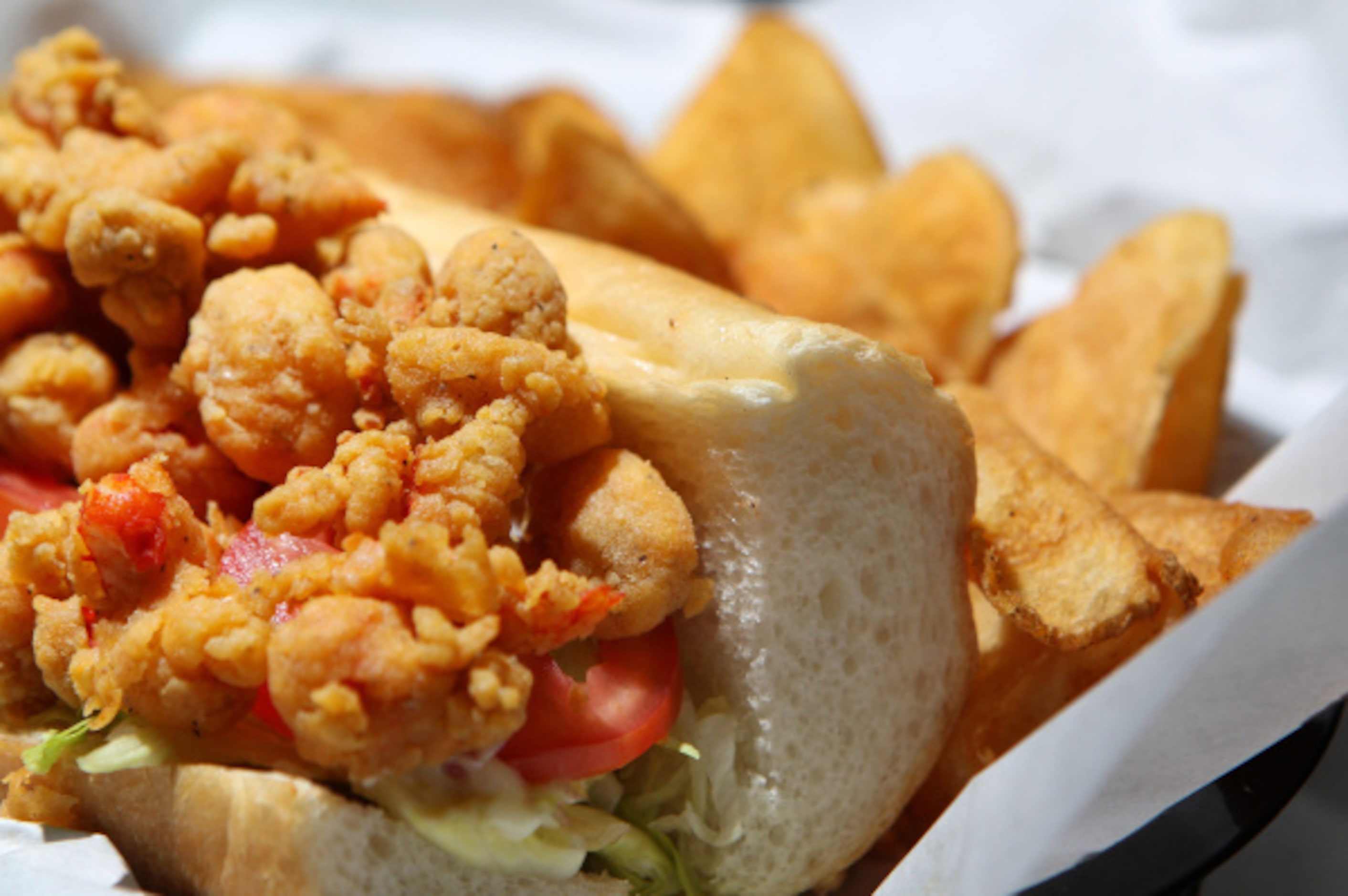 A fried crawfish po'boy at Wicked Po'Boys and Seafood. It is served on a bagutte dressed...