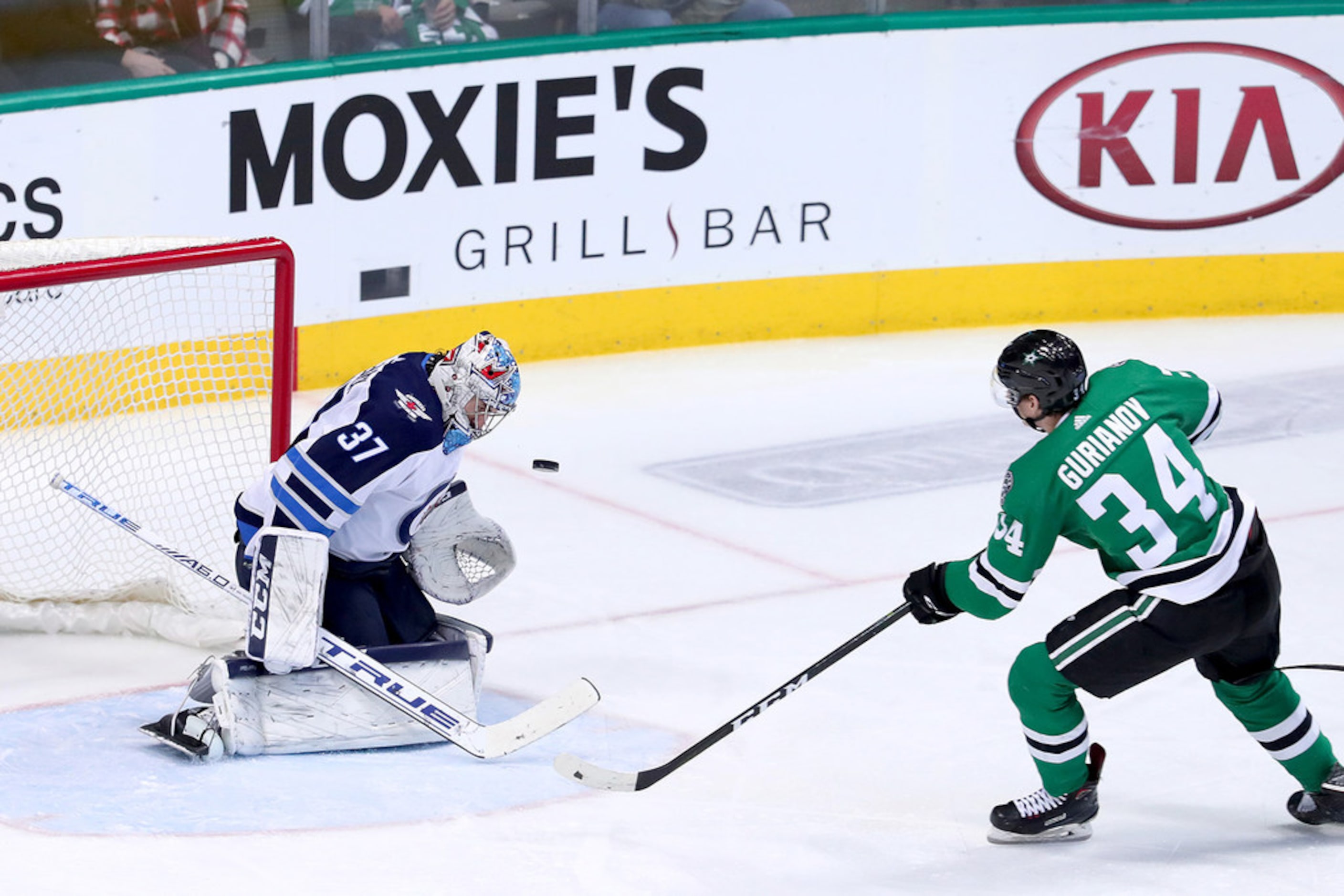 Winnipeg Jets goaltender Connor Hellebuyck (37) stops a shot on goal by the Dallas Stars'...