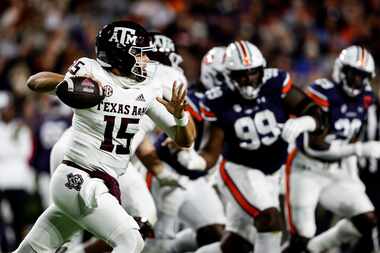Texas A&M quarterback Conner Weigman (15) rolls out to pass against Auburn during the first...