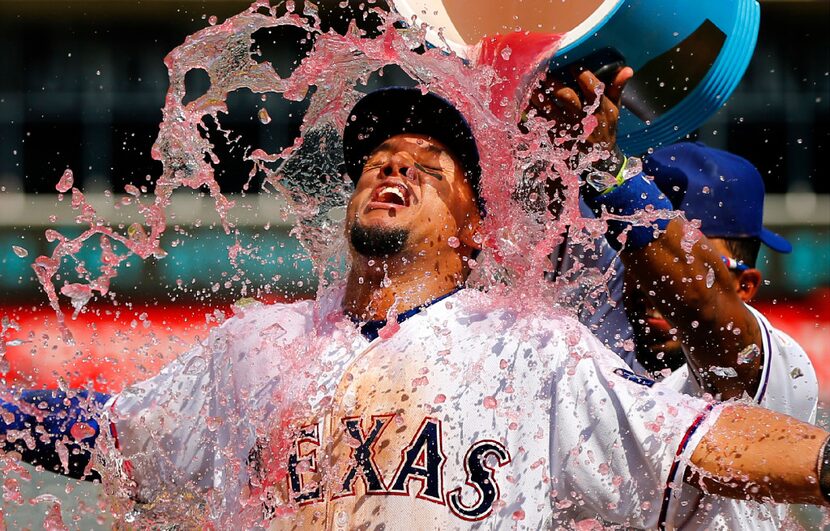 Texas Rangers left fielder Carlos Gomez relishes the sports drink dump by teammate Elvis...