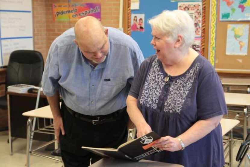 
Bertucci flips through Bishop Lynch yearbook pages with her husband, Jim.
