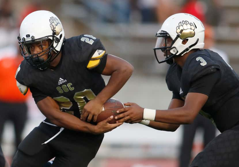 South Oak Cliff running back K.C. Cook (20) looks for an opening as he takes the handoff...