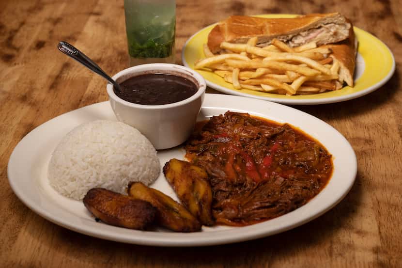 A dish of Ropa Vieja, shredded beef in a tomato sauce, with red, green peppers and onion,...