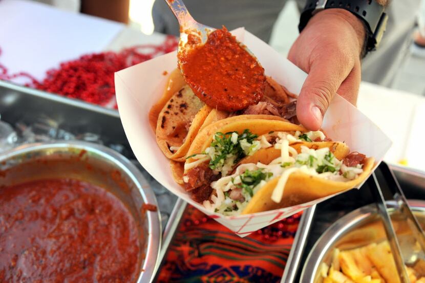 Barbacoa tacos are served with hot sauce. Sunday is National Taco Day.