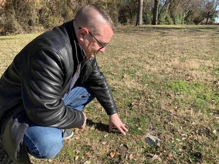 Dan Babb inspects one of the surviving markers at the old Dallas City Cemetery, which has...