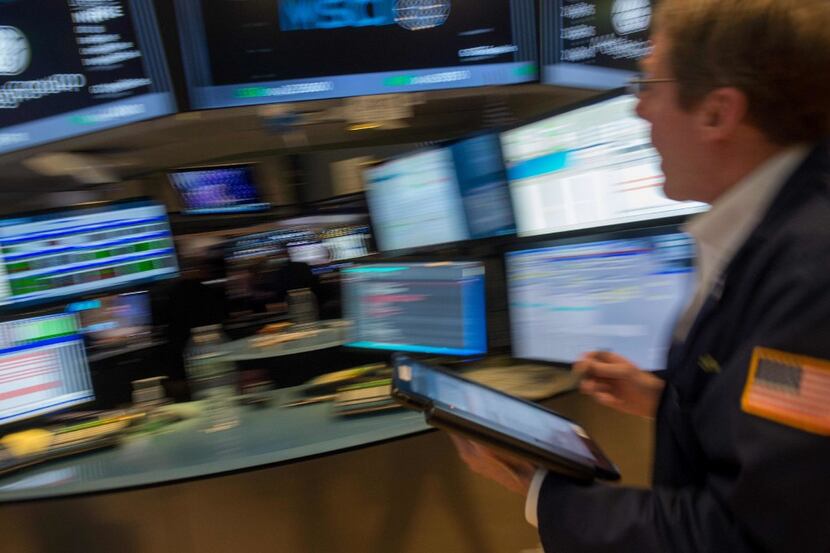 Traders work on the floor before the closing bell of the Dow Jones at the New York Stock...