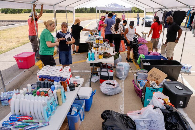 Volunteers help to organize donations during a neighborhood event to support the victims of...