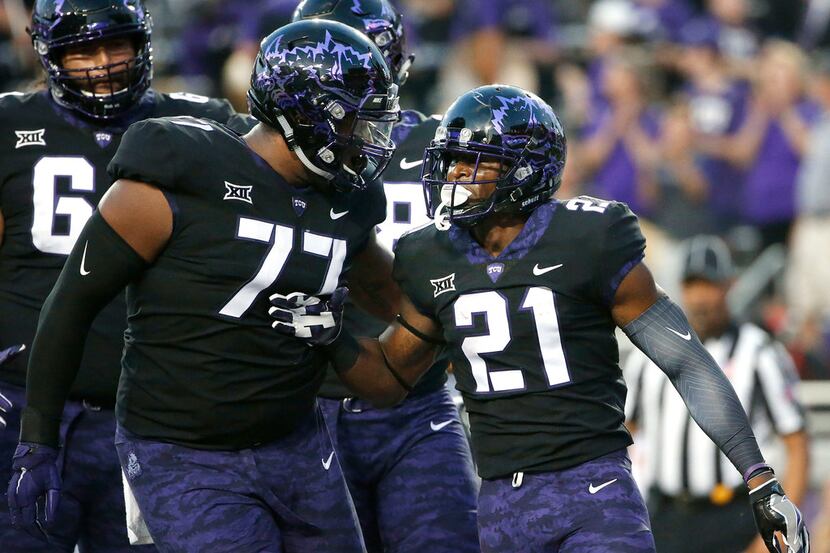 TCU's Lucas Niang (77) and running back Kyle Hicks (21) celebrate Hicks' touchdown during...