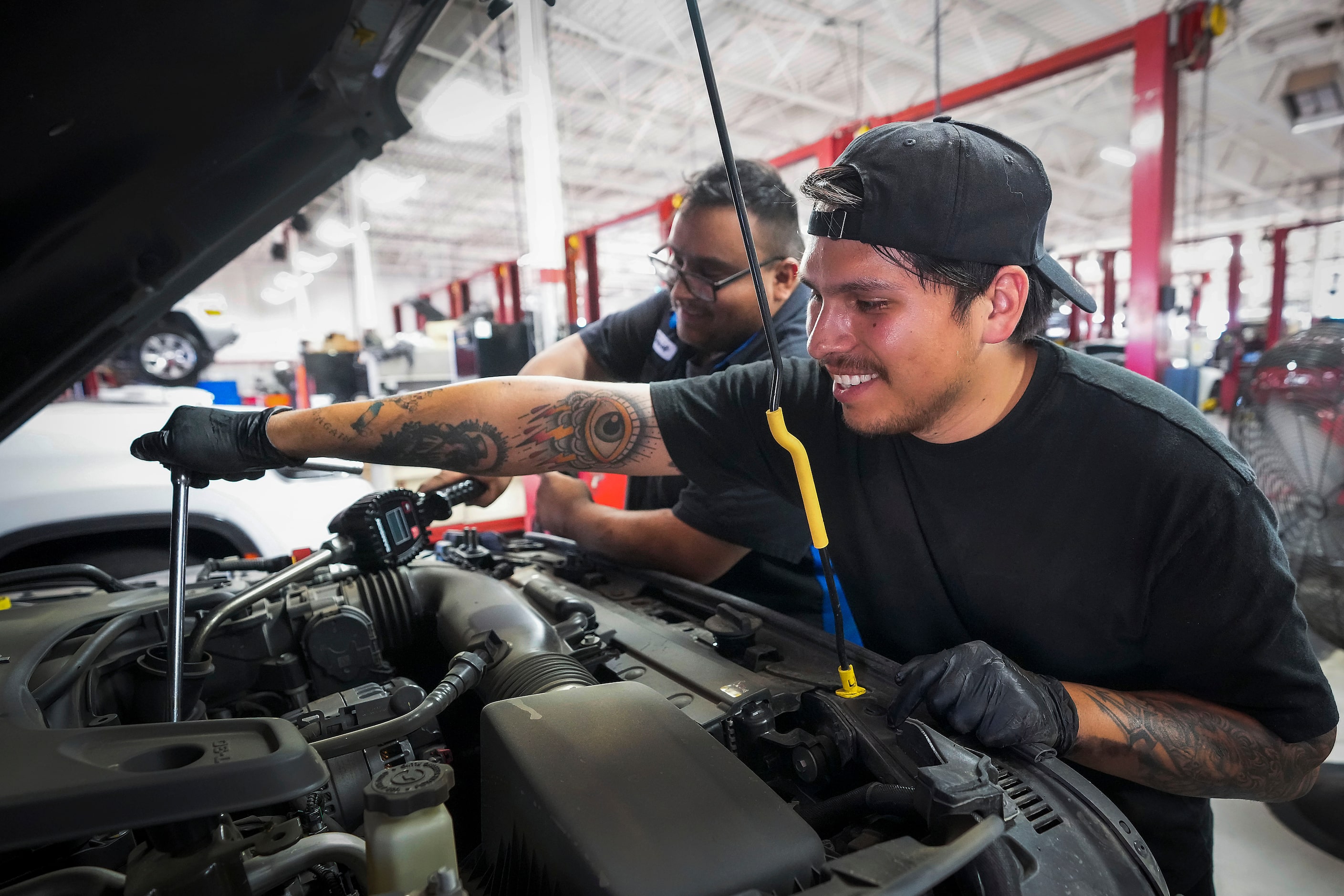 Alvaro Ramirez (front) and David Campos work in the service department at Huffines Chrysler...