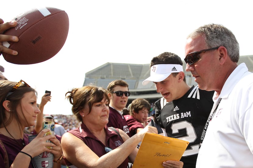 Texas A&M quarterback Johnny Manziel (2) gets mobbed by fans on the field after the Aggies'...