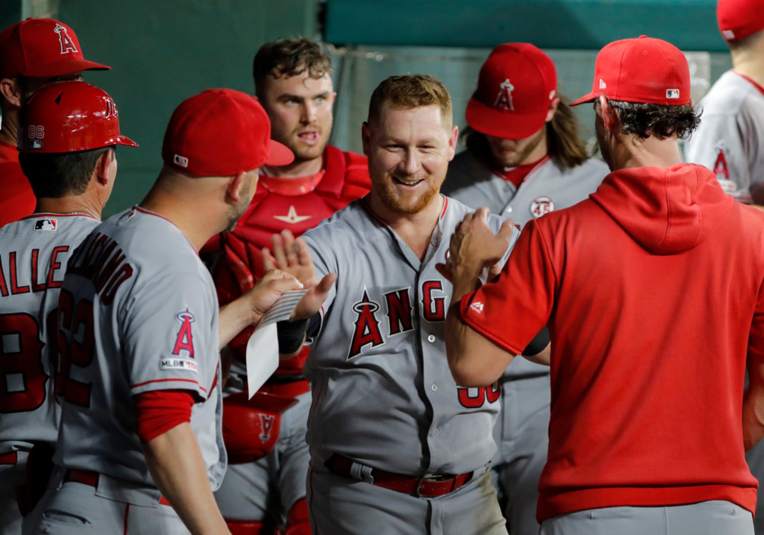 Los Angeles Angels' Kole Calhoun, center, is congratulated in the dugout after making an...