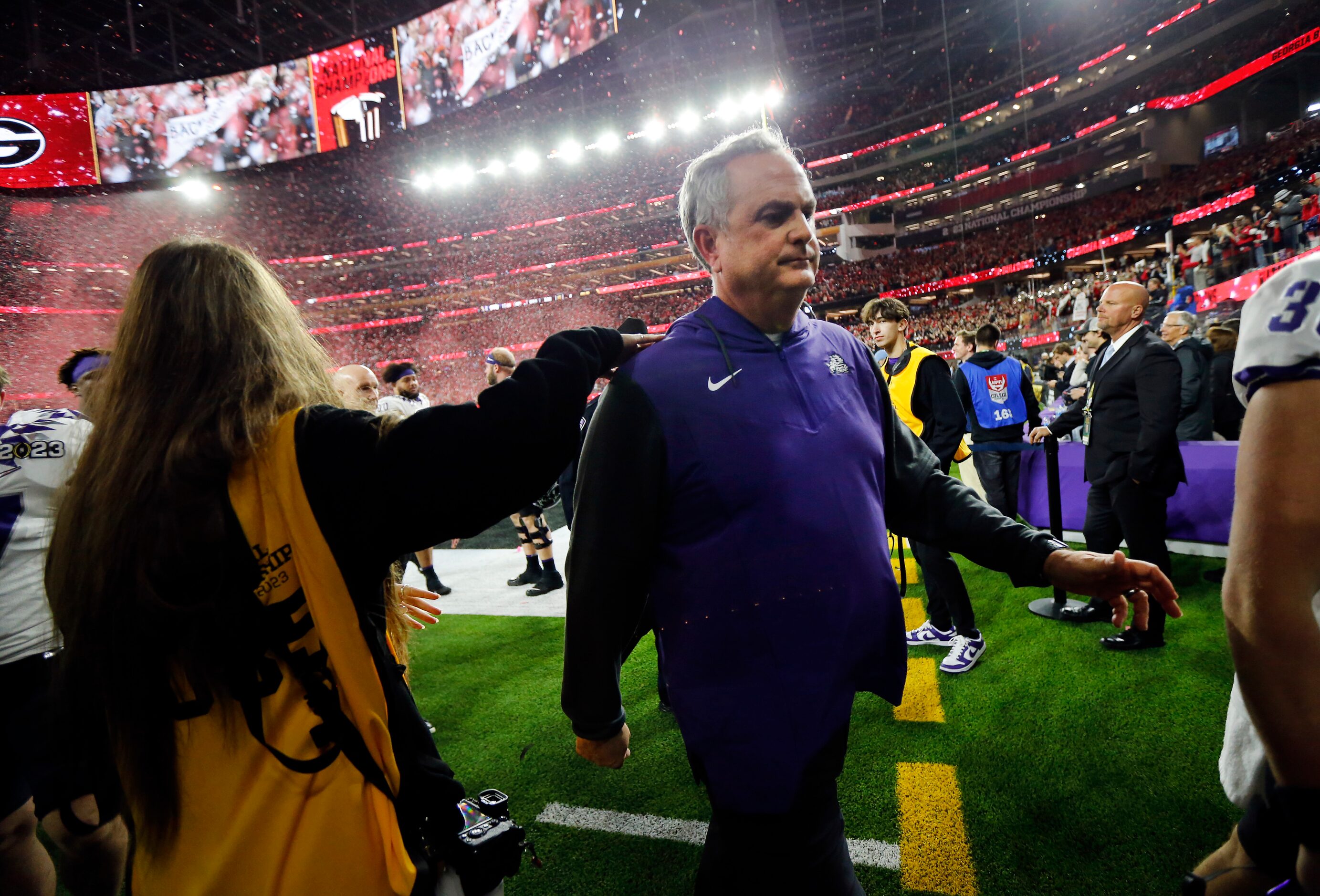 As Georgia Bulldogs red confetti rains down, TCU Horned Frogs head coach Sonny Dykes walks...