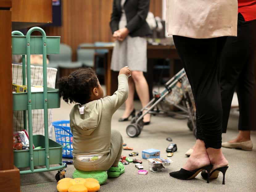 A young child played with toys as Judge Delia Gonzales oversaw proceedings in the Dallas...