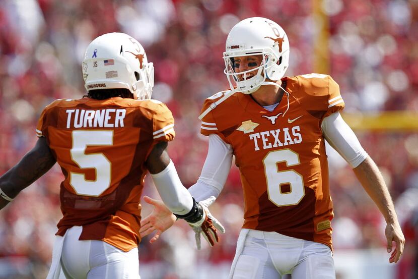 Texas Longhorns quarterback Case McCoy (6) and Texas Longhorns safety Josh Turner (5) are...
