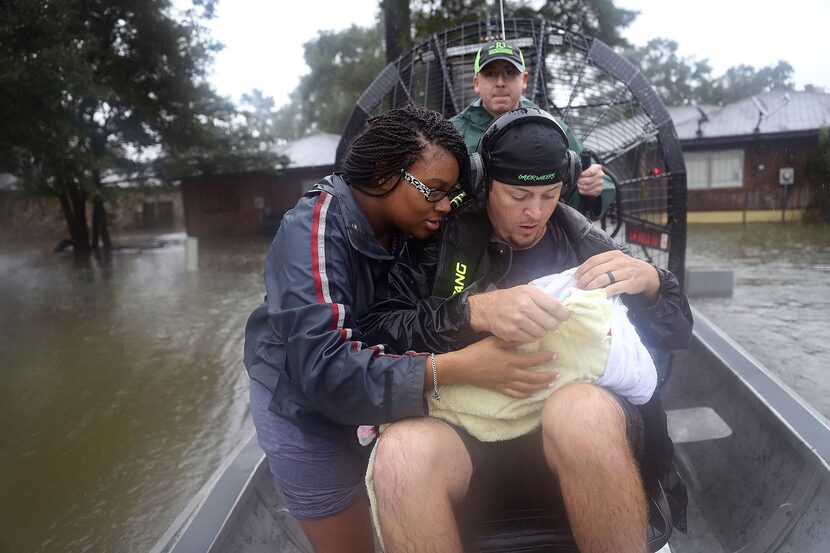 Shardea Harrison looks on at her 3 week old baby  Sarai Harrison being held by Dean Mize as...