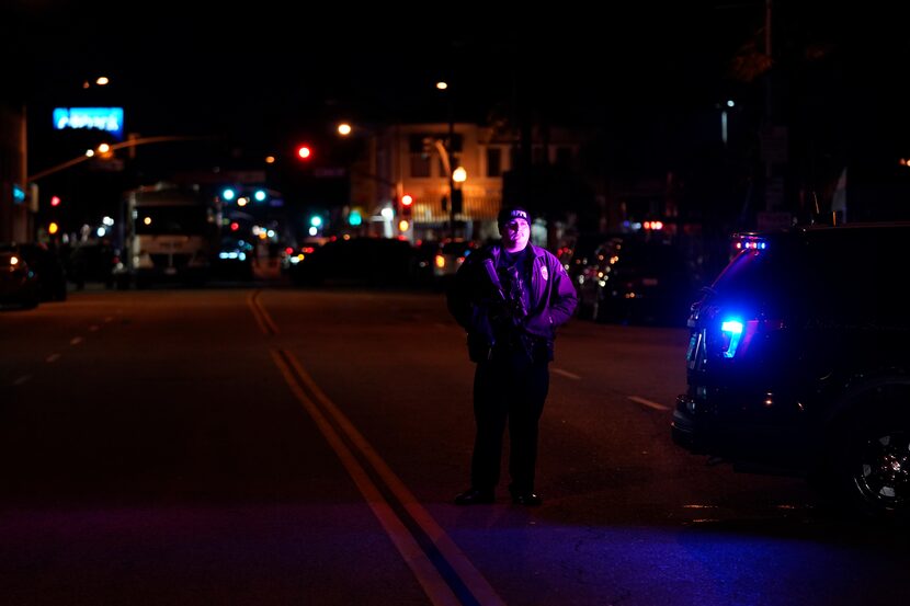 A police officer stood near a scene where a shooting took place in Monterey Park, Calif.,...