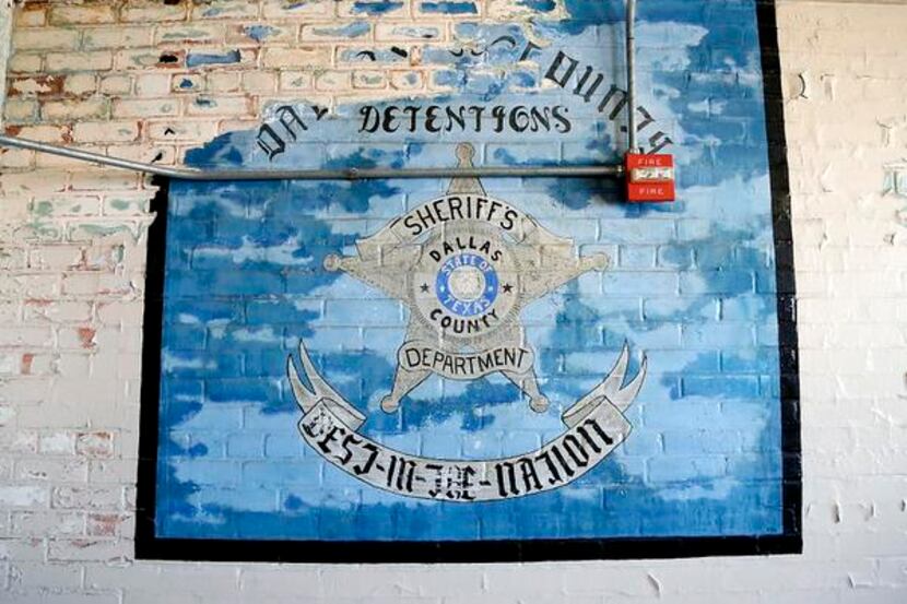 A peeling mural painted by inmates adorns the the wall of a break room in the jail section...