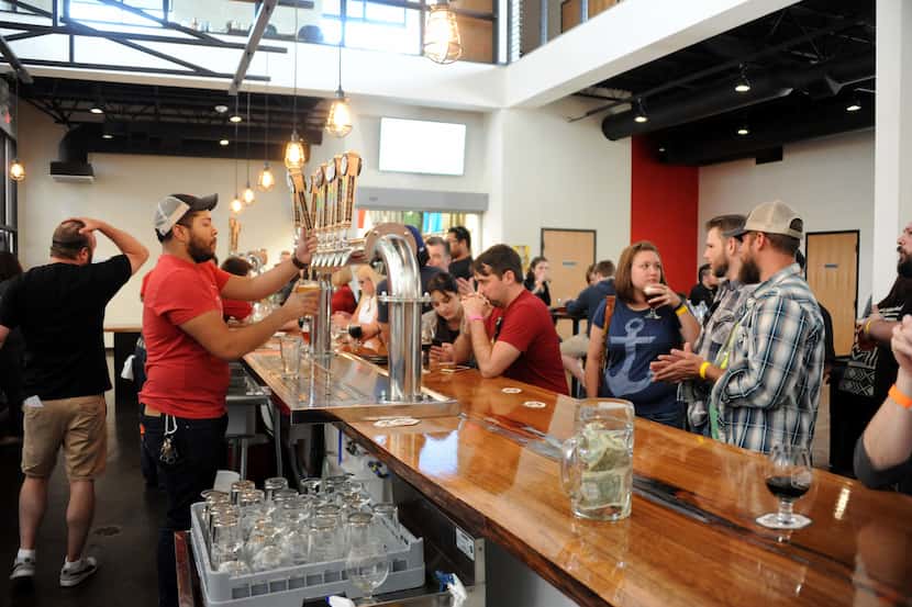 Bartender Quin Tinling serves a cold brew at Lakewood Brewing Company's  Taproom grand...