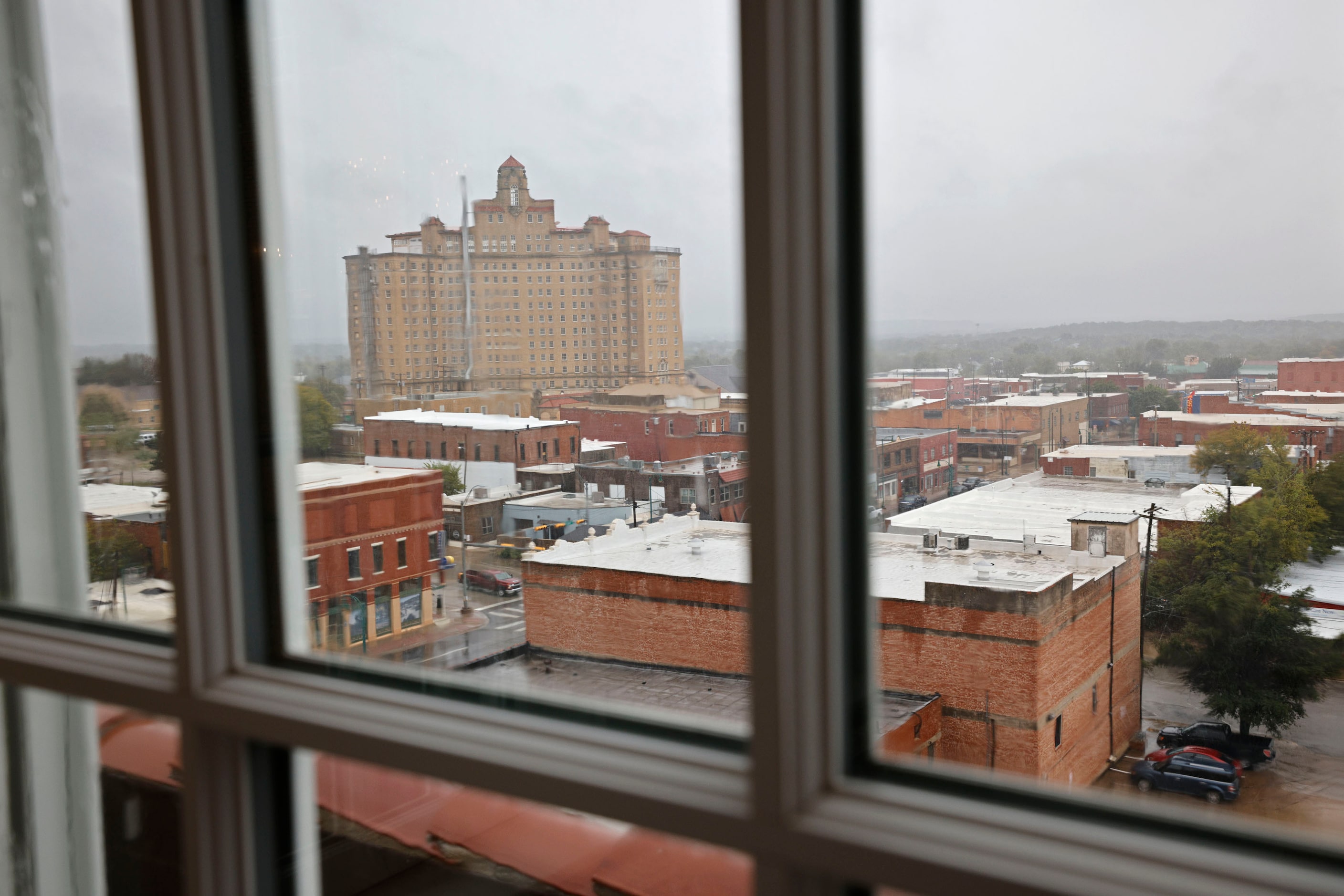 The Baker Hotel is seen through a window of The Crazy Water Hotel in Mineral Wells. The two...