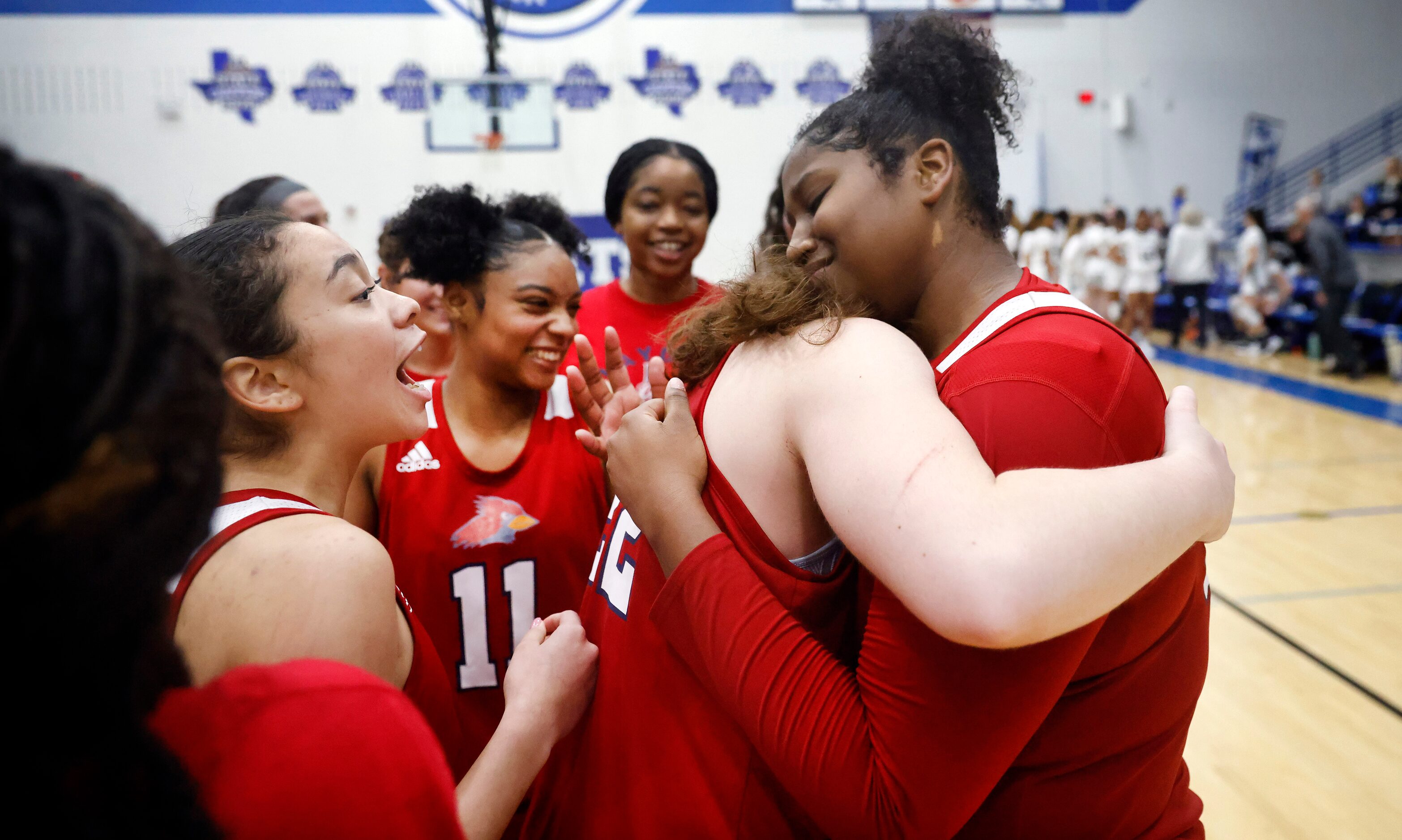 John Paul II forward Taylor Haggan (24, right) hugs teammate Clara Paynter (22) after...