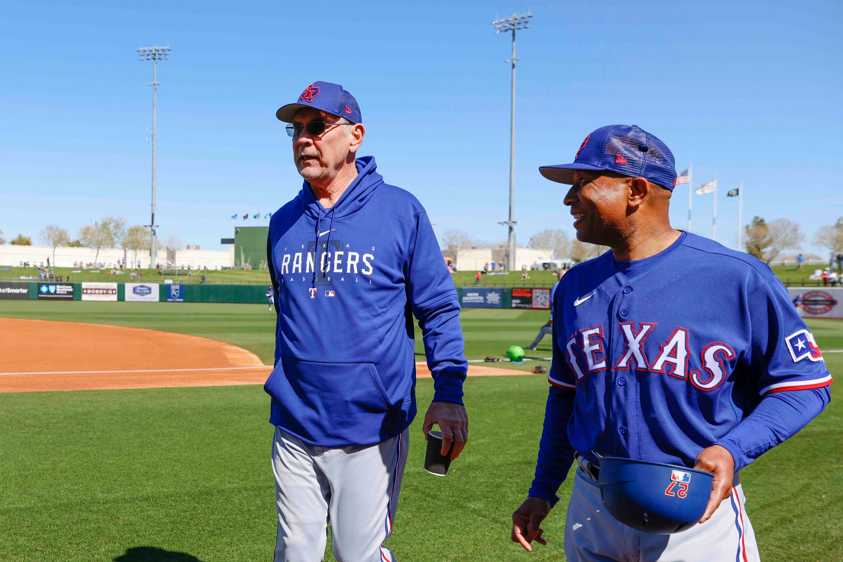 Texas Rangers manager Bruce Bochy, left, and third base coach Tony Beasley talk before a...