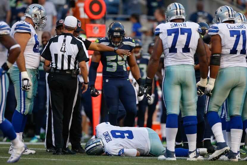 SEATTLE, WA - AUGUST 25:  Quarterback Tony Romo #9 of the Dallas Cowboys lies on the turf...