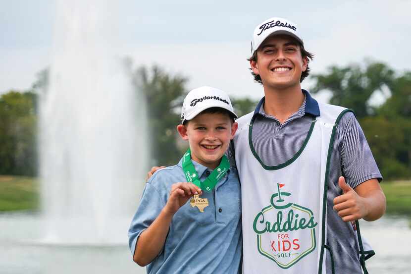 Kirk Deppe, 11, shows off his medal with caddie Pearson Kronbach of Caddies for Kids after...