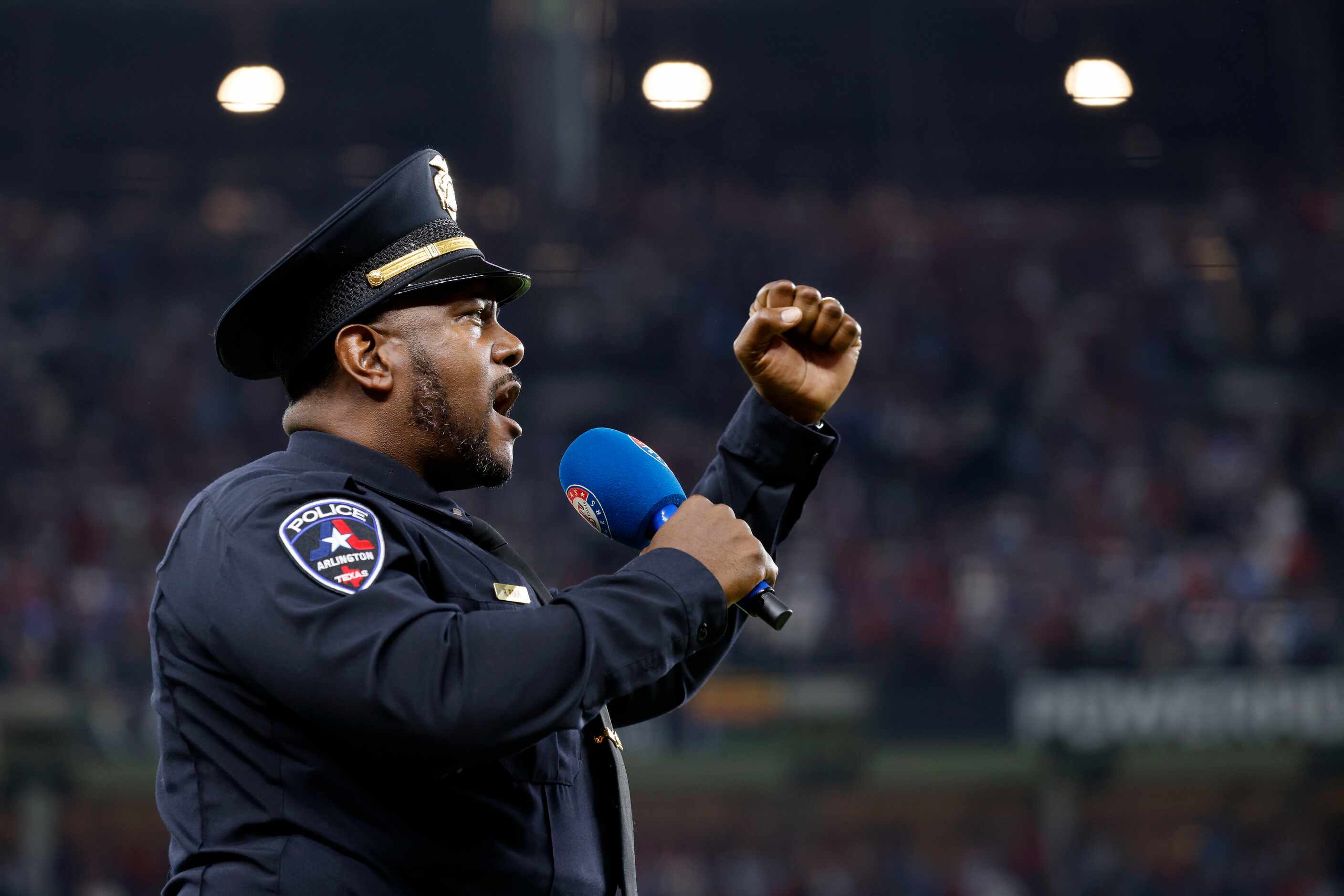 Arlington Police Lieutenant Ray Polk sings God Bless America during the seventh inning...
