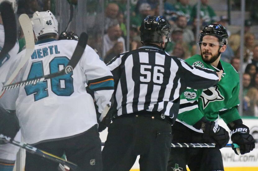 Dallas Stars center Tyler Seguin (91) mixes it up in front of the benches with San Jose...